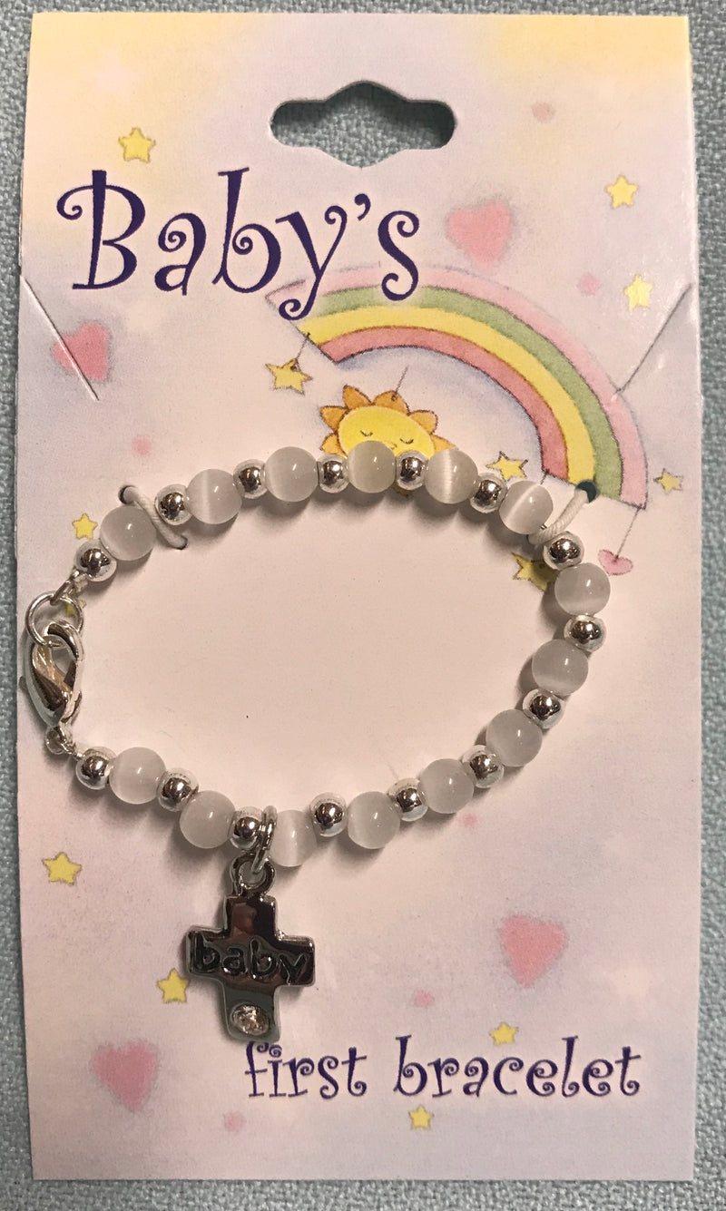 Baby bracelet with white beads and silver colored cross that says, "baby" in the center with a sparkling stone at the bottom.